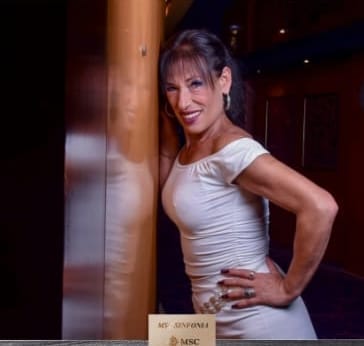 Anna Azabal con vestido blanco apoyada en una columna